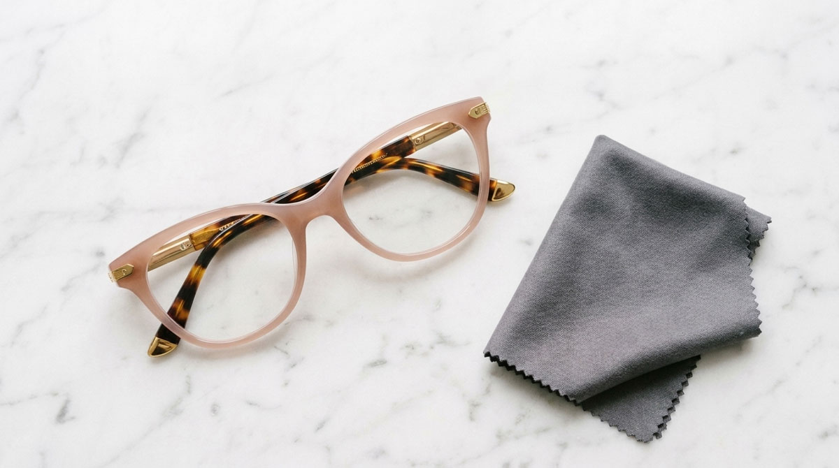 Membersihkan lensa kacamata luxury dengan kain microfiber